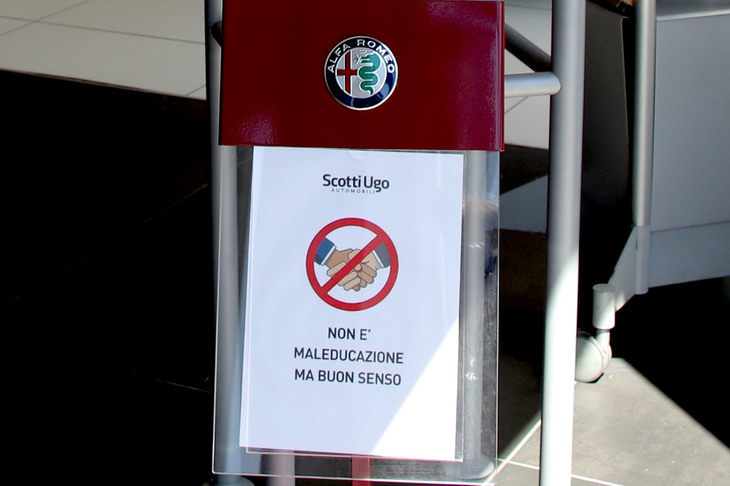 握手禁止のイラストとともに「不作法ではありません。良識です」の文字が。後述するアルファ・ロメオ／ジープ販売店にて。