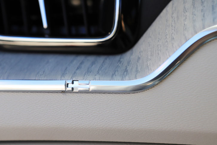 インストゥルメントパネルの金属製トリムには、スウェーデン国旗の装飾があしらわれる。湿度や熱により伸縮するウッドパネルのダメージを抑える効果もあるという。