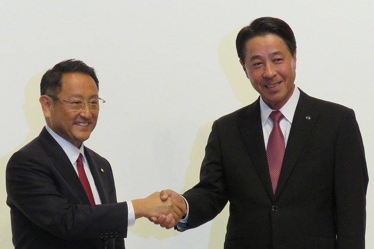 2017年8月に行われた資本業務提携に関する記者会見にて、握手を交わすトヨタ自動車の豊田章男社長（左）と、マツダの小飼雅道社長（右、当時）。「EV C.A. Spirit」の設立は、この翌月に発表された。