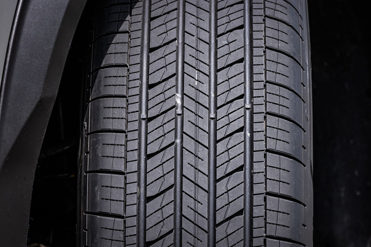 シンプルなパターンと小さめのブロックが並ぶ「アシュアランス マックスガードSUV」のトレッド面。ブロックに角度をつけることでタイヤが路面をたたくときの音を抑える一方、両側に設けた細い「ノイズ低減リブ」が溝で発生する“気柱共鳴音”の広がりを減らす。