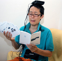 フィリップス製ビデオトランスミッターの説明書と格闘する筆者。