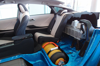 トヨタ内製の高圧水素タンク（写真の黄色い容器）は、後席の下と荷室の下に、計2本が搭載される。容量は合わせて122.4リッター。空の状態からは、約3分でフルに充填できる。写真はカットモデル。
    