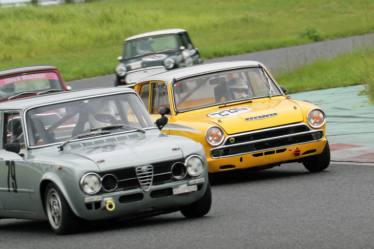 スーパークリスタルカップ／ハイパークリスタルカップ混走での中団のバトル。左の「アルファ・ロメオ・ジュリア スーパー」は8位（スーパークリスタルでは3位）、右の「コルチナ・ロータスMk1 Sr2」は7位（ハイパークリスタルでは5位）。