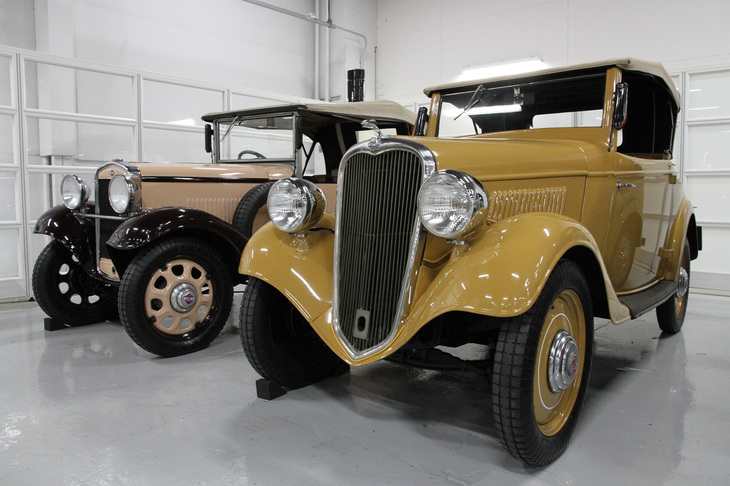 左は所蔵車両の中で最も古い1933年「ダットサン12型フェートン」。右は、現在もメインの建屋がゲストホール／エンジン博物館として使われている、かつての横浜工場のラインで作られた最初の量産モデルである1935年「ダットサン14型ロードスター」。1950年代に超軽量ミニカー「フライングフェザー」なども手がけた、著名な工業デザイナー／エンジニアである富谷龍一氏によるエクステリアデザインが魅力的だ。