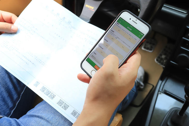 まずは車検証の確認から。車両の基本情報を専用アプリの入ったスマートフォンに記録していく。