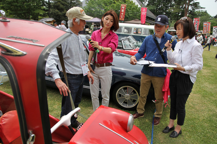 恒例となっている、ピックアップされた車両のオーナーインタビュー風景。聞き手はゲストであるモータージャーナリストの飯田裕子氏（写真右端）と主催するサクラモータークラブ副会長の坂田芳一氏（右から2人目）。
