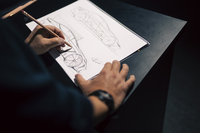 デザイナーによるライブデッサンの様子。まずは地面とタイヤを描き、そこから全体を仕上げていく。