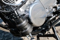 クランクケースの左前には、蒸発ガソリンの大気放散を抑えるキャニスター（写真の黒いタンク）が装着される。シンプルな外観を好む「SR」ファンにはやや気になる補器だろうが、ヤマハとしては、固定するためのラバーバンドやホース類に至るまで、少しでもスタイリッシュに見えるよう工夫したという。