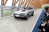 会場裏手より、自走でステージへと向かう「アクシー」。同車には、GLMのスポーツEV「トミーカイラZZ」のプラットフォームが用いられている。