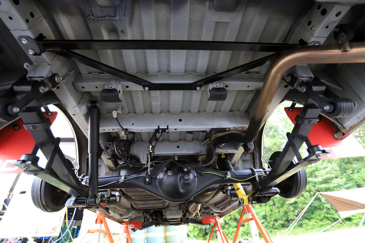 リアサスペンションからの入力によるボディー変形量を減らす役割を担う「メンバーブレースセット」（写真手前の台形のパーツ）。AXCRで培ったノウハウが生かされた「ショックアブソーバー」との同時装着が推奨されている。