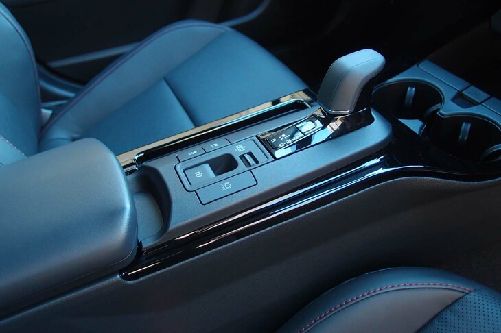 シフトセレクターやパーキングブレーキは電子式。その隣（助手席側）に見える溝は、スマートフォンを縦に挿入して使う非接触充電スロットである。