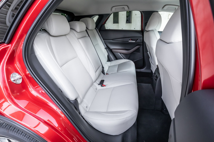 「CX-30」の後席は、「CX-3」比で前後座席間距離が＋26mm、左右座席間距離が＋50mmとなっており余裕が感じられる。背もたれには60：40の分割可倒機構が備わる。