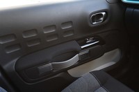 くぼみのあるドアパネルやベルト状のドアノブも個性的なディテールのひとつ。明るい配色のドアポケットは内部の視認性に優れる。