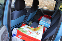 トイレットペーパーにキッチンペーパー……。生活感あふれるリアシート。足元には、カリフラワーが転がっていた。