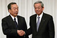 握手をするトヨタ自動車の内山田竹志取締役副社長（左）とマツダの山木勝治代表取締役副社長執行役員。