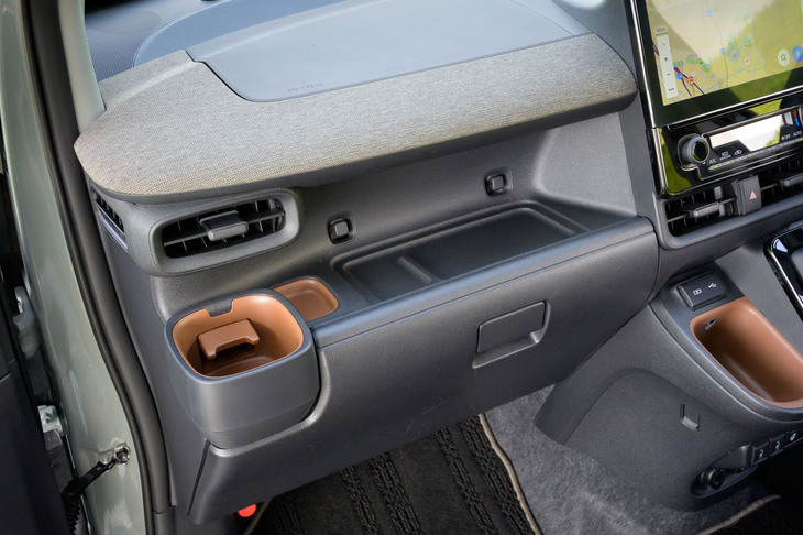 「シエンタ」の助手席前方は深く掘り込まれたトレーに。2つの突起にはUSBケーブルを巻きつけて収納可能で、カップホルダーにはわざわざキャップ置き場が用意されている。