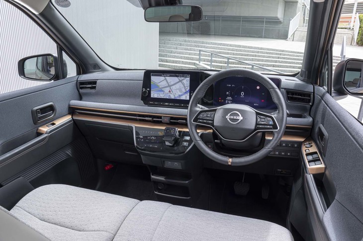 ファブリックが大胆に使われたダッシュボードは既存の軽自動車とは一線を画す質感だ。助手席の前方は大きくえぐられ、スマートフォンなどが置けるようになっている。