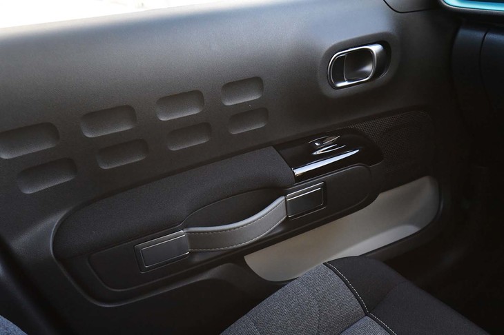 くぼみのあるドアパネルやベルト状のドアノブも個性的なディテールのひとつ。明るい配色のドアポケットは内部の視認性に優れる。