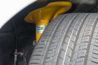 「Sエディション」専用装備のビルシュタイン製ダンパーをのぞき見る。サスペンション形式は、全車ともフロントがストラット式でリアがマルチリンク式。