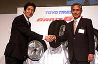 東洋ゴム工業の片岡善雄代表取締役（右）と握手をするのは、「ガリットG4」のテレビCMに出演する、タレントの宮川俊二さん。