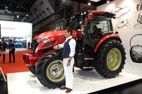 デザインを手がけた大型トラクターの量販モデル「ヤンマーYT5113」とともに写真におさまる奥山清行氏。