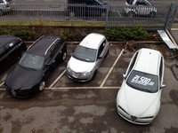 階下の屋外新車展示場を見渡す。ホワイトの「アルファ159 スポーツワゴン」は今月限り価格2万1500ユーロ（約236万5000円）。