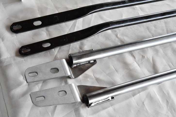 ドアスタビライザーとの併用が推奨される、ボディー下部の強化型「ブレース」（写真下2本）。標準タイプ（写真上2本）に比べ、パイプの直径は太く（19mm→22mm）、厚さは薄く（2mm→1.6mm）なっている。