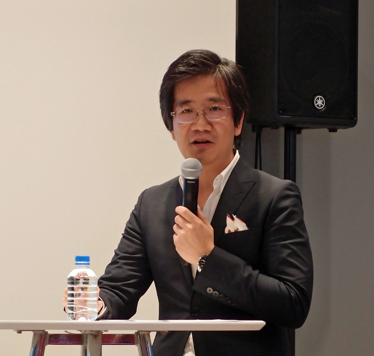 「モデル3」の概要について説明する、テスラジャパン カントリーセールスディレクターの吉田篤司さん。モデル3については、EVであることよりもむしろ、走行性能や安全性に優れている点に注目してほしいと語る。