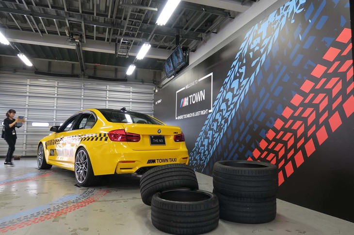 仮想都市「Mタウン」で走行している「M TOWN TAXI.」がバーチャルの世界を飛び出し、富士スピードウェイに登場。Mタウンガレージを模したフォトスポットでの撮影サービスのほか、同乗走行イベントも実施されていた。