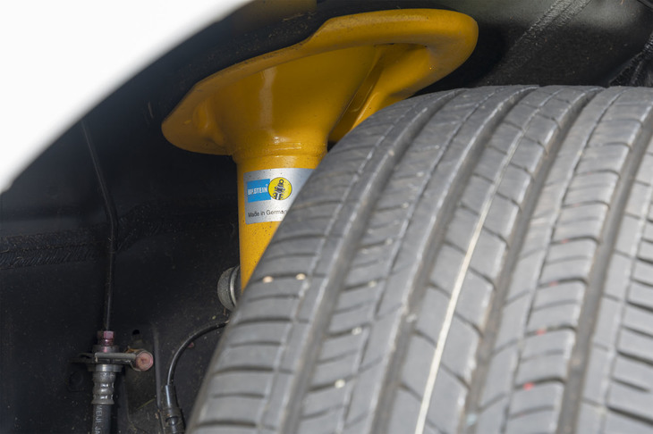 「Sエディション」専用装備のビルシュタイン製ダンパーをのぞき見る。サスペンション形式は、全車ともフロントがストラット式でリアがマルチリンク式。