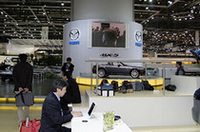 マツダブースの前にて、iBookで仕事の図。