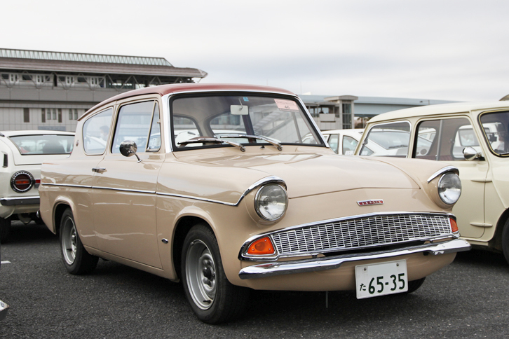 1967年「フォード・アングリア デラックス」。映画『ハリー・ポッター』に登場したことで、日本でもその名を知られるようになった、英国フォードのボトムラインを支えた大衆車。クリフカットのリアウィンドウが特徴的なボディーに、1リッター直4 OHVエンジンを積む。