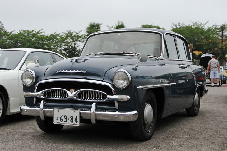 1957年「トヨペット・クラウン デラックス（RSD）」。1955年に誕生した初代クラウンの高級グレード。ちなみにデビュー時はスタンダード相当のモノグレードで、遅れてこのデラックスが追加された。フロントグリルは、その形状から俗に“ブラジャーグリル”と呼ばれる。