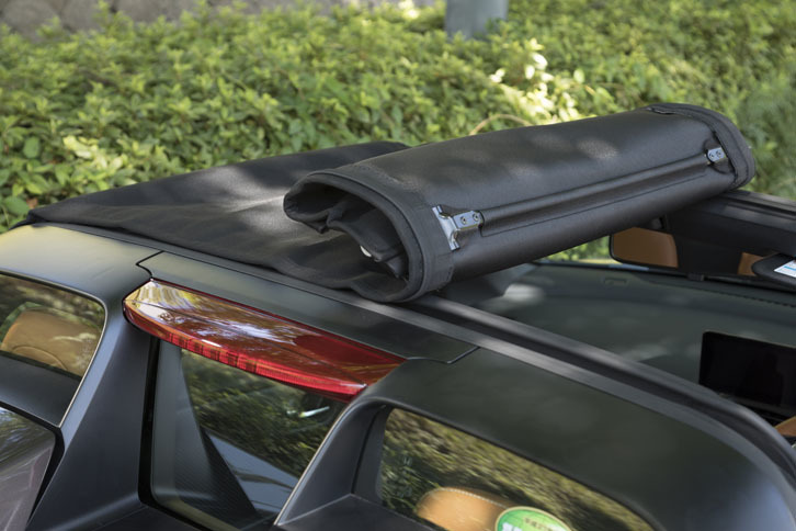 「ロールトップ」と呼ばれるルーフは、2カ所のロックを外せば左右どちらからでも簡単に巻き取ることができる。取り外したあとは、ボンネット下に収納できる。