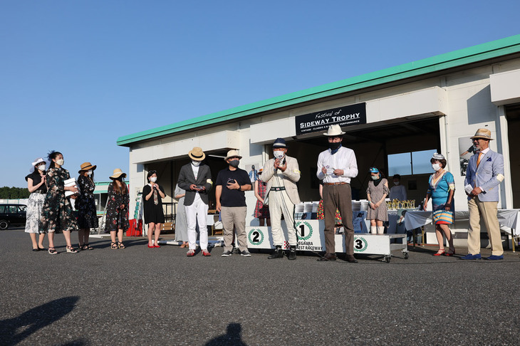 全レース終了後、パドックで表彰式を実施。各賞の最後に表彰されたのは、10年間に開催されたすべてのレースに参戦した皆勤賞。スピーチしている、エバーグリーンカップで優勝した関口好夫氏（写真の前列右から2人目）ら4名にクリスタルの盾が贈られた。