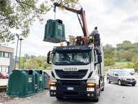 ダストボックスを車載クレーンでつり上げる。