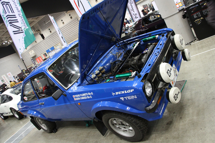 サスペンションメーカーのTEIN（テイン）が展示していた「フォード・エスコートRS1800」。フォード・オーストラリアのワークスカーで、1980年のサザンクロスラリーでアリ・バタネンがドライブ、3位に入った戦績を持つ個体という。これを見て、型式名KB110こと2代目「サニー クーペ」と思った入場者もいたに違いない。