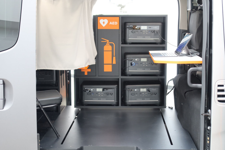 日産ディザスターサポートスペック（折り畳みテーブルのある作業スペース／写真奥はポータブルバッテリー from LEAF）