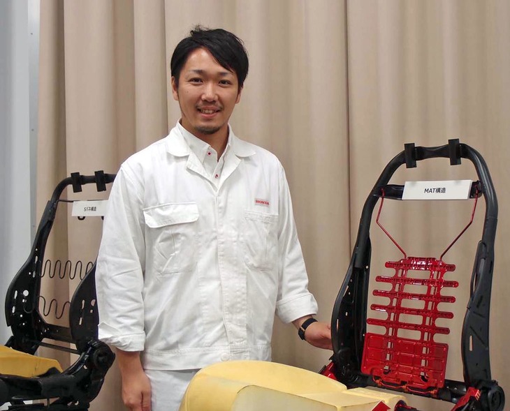 新開発のシートフレーム（写真右）を前に笑顔を見せる森下勇毅さんは、内装設計のスペシャリスト。デザイナーの小野結樹さん（次写真）と二人三脚で新型「フィット」のインテリアを仕上げた。