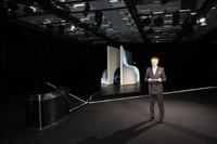 暗闇の奥に水滴を模した白いオブジェが置かれ、その隙間からブガッティグリルが見えている。