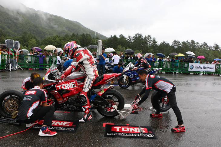 8耐参戦マシンの「ピットタイヤ交換」のデモンストレーション。3チームによるバトル形式で行われ、腕利きのメカニックたちが素早く作業を終える光景を観覧者たちは食い入るように見つめていた。