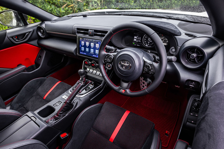 最新型「GR86」のインテリア。内装に大きな手は加わっていないが、ウインカーレバーが操作した先でカチャッと固定されるロック式に変更されている。「RZ」グレードは、内装色が写真の「ブラック×レッド」または「ブラック」から選択できる。