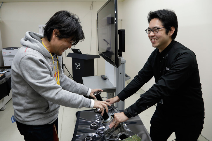 新旧2種類のトランスファーの抵抗を、実際にプロペラシャフトを回転させて体感する筆者（写真左）。