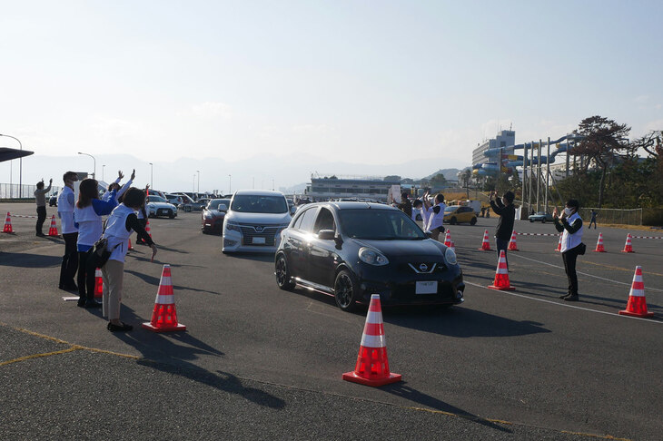 NMCのスタッフが手を振って見送るなか、会場を後にする参加車両。次回も多くのクルマが、湘南（厳密には大磯だけど）に帰ってくることだろう。