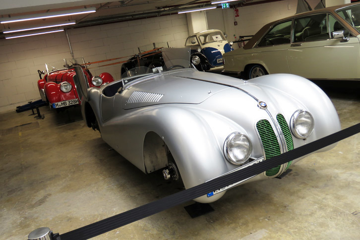 収蔵庫の奥にはタイヤを外された「BMW 328」の姿が。実はこちら、クラシックカーラリーの「ミッレミリア」に参加するため、目下整備中なのだとか。なお、手間のシルバーの個体は、1940年の（本当の）ミッレミリアで3位に入ったクルマとのこと。