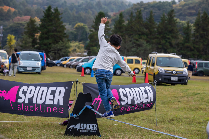 スラックラインの体験ブース。インストラクターのレクチャーによって、ほとんどの人が初めてでもラインの上を歩けるようになるという。「一度やってみたかった」と、家族で楽しむ姿が見られた。