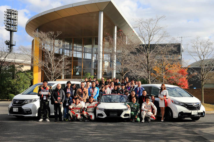 参加者全員での記念撮影。今回は「スポーツカー試乗」に20人、「ミニバン試乗」に12人（同伴者は除く）が参加した。スペシャルゲストとして、開発アドバイザーである土屋圭市さんをはじめ、モデューロとゆかりの深いレーシングドライバーたちも参加。イベントを盛り上げた。