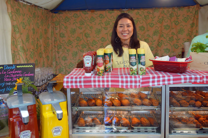スタッフの方がすてきな笑顔を向けてくれた地元・代官山のフレンチビストロ、ル・コントワール・オクシタンのブース。ケースの中に並ぶのは、写真左は、ソーセージにジャガイモとチーズを巻いた、フランス流“アメリカン”ドック。写真右はほたるいかのフライ。