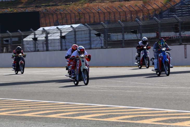 オフロードとロードレースの選手たちが混合で挑んだレース「Cub Mix MATCH」は、スーパーカブで戦われるレース。レースカラーをまとっているが、マシンは、ノーマルのスーパーカブ。カテゴリーは違えど、プロ同士の戦い。皆の闘志がみなぎっており、ライディングスタイルは、空気抵抗を減らそうとマシンと一体化するようなポジションに。