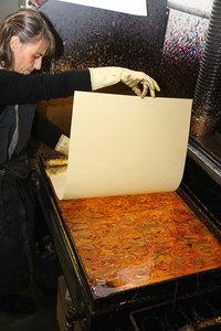 カテリーナさんはマーブル紙工房を営んでいる。これは図柄を紙に転写しているところ。